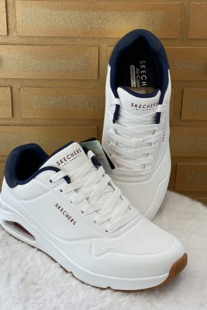 Découvrez la basket homme Skechers Uno Suited On Air blanche, sneaker confortable avec amorti Air visible, idéale pour un usage quotidien. Disponible chez Euridys Chaussures à Arcachon.
